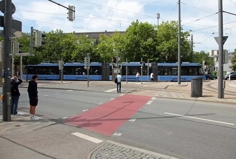 A low-floor MVG tram at the level-boarding Romanplatz terminus in Munich, showing step-free, barrier-free access